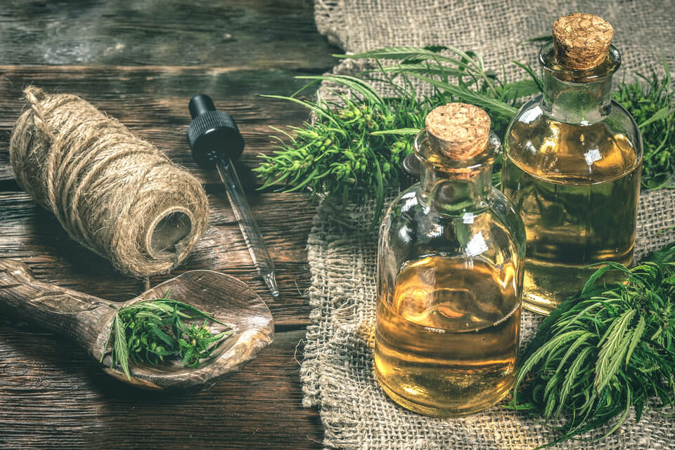 Prirodno CBD ulje u staklenim bočicama s ekstraktom konoplje na drvenom stolu