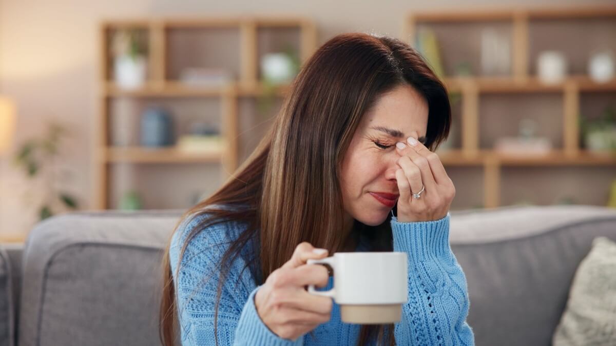 Žena s kavom osjeća brain fog i pad fokusa nakon ispijanja kave.